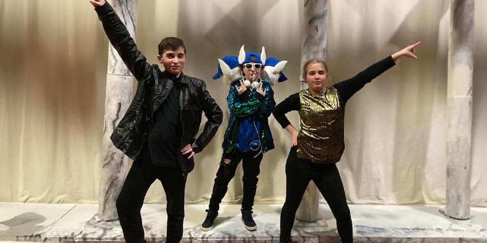 Three students from the Deaf and Hard of Hearing program striking theatrical poses on the set of The Lightning Thief.