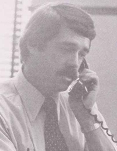 A black and white closeup photo of a young Bob Foley talking on a phone in the 1980s.