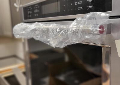 Close up of new stainless steel teaching kitchen oven with a black electronics panel.