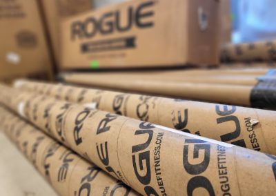 Close up of boxes of fitness center equipment labeled with the fitness brand name, Rogue.