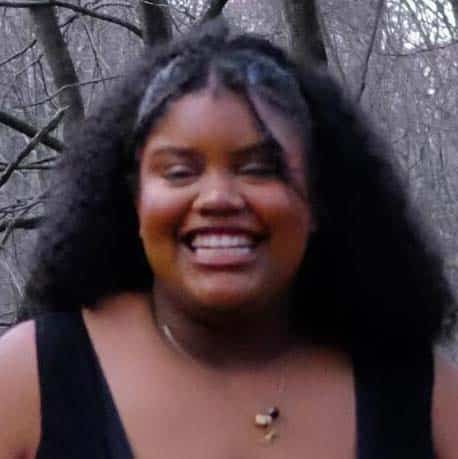 Lucy with a big smile toward the camera in her senior photo.